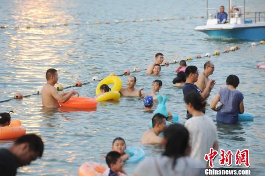 合肥市民在天鹅湖边戏水纳凉。　张娅子　摄