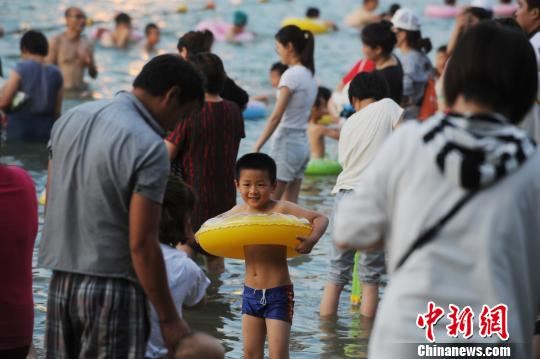 合肥市民在天鹅湖边戏水纳凉。　张娅子　摄